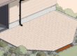 A paver patio beside a house, sloping toward an orange-accented garden drain.