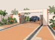 Pickup truck parked inside a paved gate entrance with palms and drainage channels.