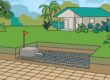 A paver patio stops before a grassy septic field marked by an orange stake.